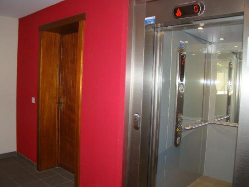 a bathroom with a shower and a red wall at Mar Mar Appartaments in Briançon