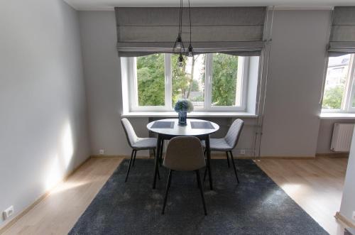 - une salle à manger avec une table, des chaises et 2 fenêtres dans l'établissement Flat For Rent Panevezys, à Panevėžys