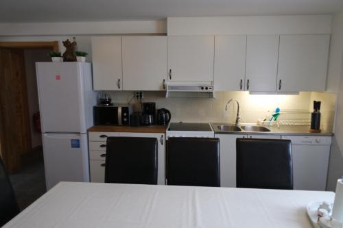 a kitchen with white cabinets and a white refrigerator at Hedemora Logi in Hedemora