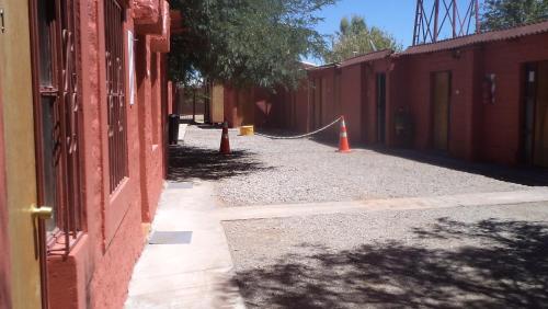 an alley with two orange cones next to a building at Hostal Las Kañas in San Pedro de Atacama