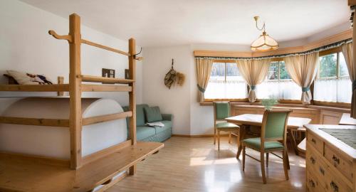 a bedroom with a bunk bed and a table and chairs at Villa Ortensia in San Vigilio Di Marebbe