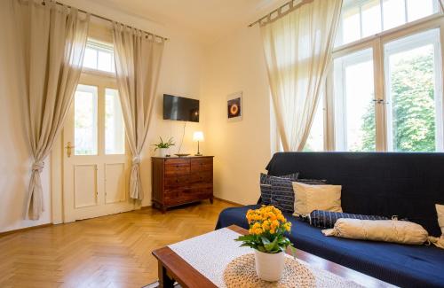 a living room with a blue couch and a table at Vila Heide in Česká Kamenice