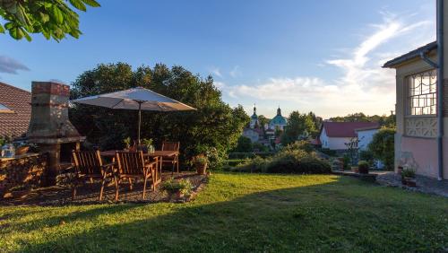 a table and chairs with an umbrella in a yard at Vila Heide in Česká Kamenice
