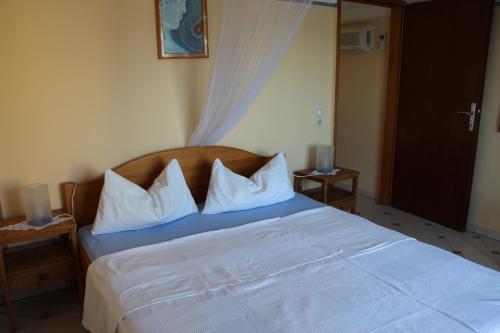 sypialnia z łóżkiem z białą pościelą i poduszkami w obiekcie Apartment Rosa w mieście Neviđane