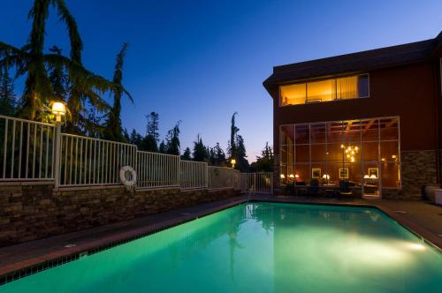 a swimming pool in front of a house at night at Olympic Lodge by Ayres in Port Angeles