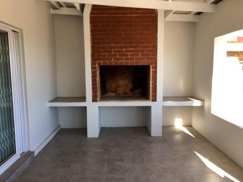 a living room with a fireplace and a brick wall at Lazy Days Apartments - Lambert's Bay in Lambertʼs Bay