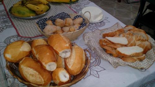 a table with two baskets of bread and fruit at Pousada Moporã, a antiga pousada do Waldir, com amplas suítes no centro de Aiuruoca in Aiuruoca