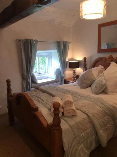 1 dormitorio con 1 cama grande y toallas. en White Cottage Askham en Askham