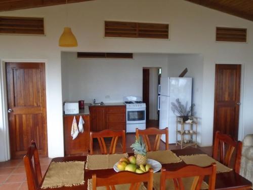 a kitchen and dining room with a table with fruit on it at Cabier Ocean Lodge in Crochu