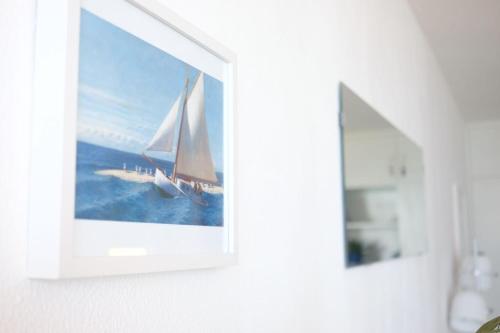 a picture of a sail boat in a painting on a wall at Doñana 414 in Patalavaca