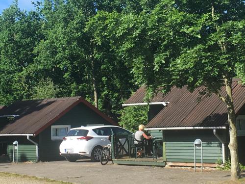 a man sitting on a porch next to a car at Dancamps Trelde Naes in Fredericia