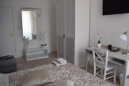 a white room with a bed and a desk and a mirror at My Bed Vatican Museum in Rome
