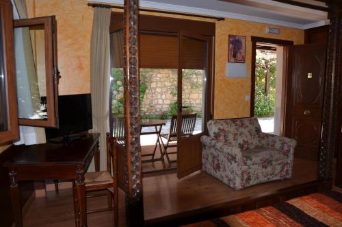 a living room with a chair and a table at Hotel Arenas de Cabrales- apartamentos in Arenas de Cabrales