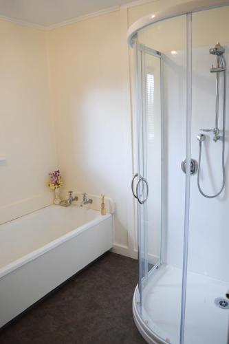 a bathroom with a shower and a tub and a sink at The Greytown Hotel in Greytown