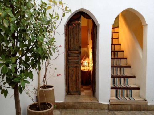 a hallway with a wooden door and stairs at Riad Le Coq Berbère in Marrakech