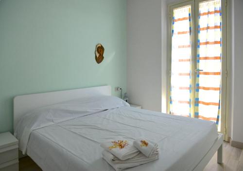 カルロフォルテにあるCasa Giancaのベッドルーム1室(白いベッド1台、タオル付)