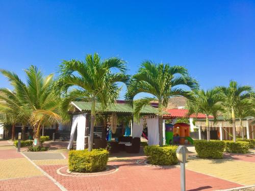 a house with palm trees in a parking lot at Hotel Casa Playa Zorritos in Zorritos