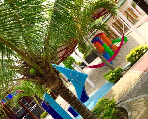 a palm tree in front of a playground at Hotel Casa Playa Zorritos in Zorritos