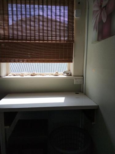 een raam in een kamer met een witte tafel en een raam bij Napier Art House Backpackers in Napier