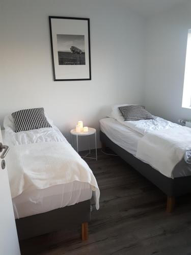 ヘトラにあるHellatún Guest House!のベッドルーム(キャンドル付きテーブル付)のベッド2台