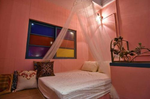 um quarto com uma cama e uma janela em Green House em Tainan