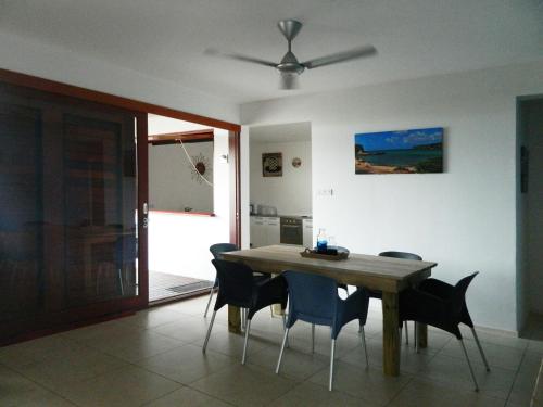a dining room table with chairs and a ceiling fan at Hilltop Sea view , Boca Gentil in Willemstad