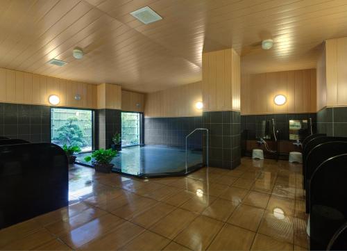 une grande chambre avec une douche en verre dans un bâtiment dans l'établissement Hotel Route-Inn Kamaishi, à Kamaishi