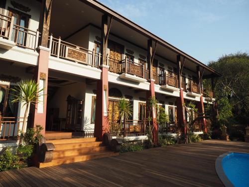 a building with a balcony and a swimming pool at Amata Lanna Village อมตะล้านนาวิลเลจ in Chiang Mai