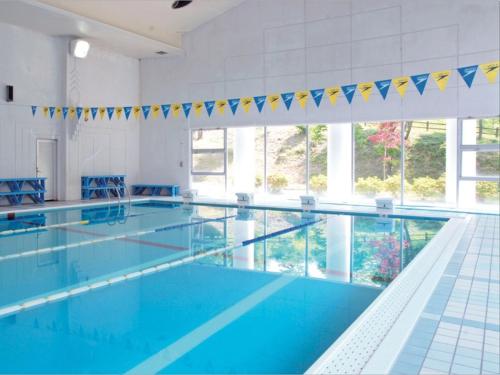 a large swimming pool with blue water and blue chairs at Renaissance Tanagura in Shirakawa