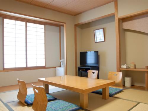 a living room with a wooden table and chairs at Renaissance Tanagura in Shirakawa