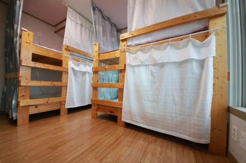 a room with two bunk beds and a ladder at Bangdigareum B&B in Seogwipo