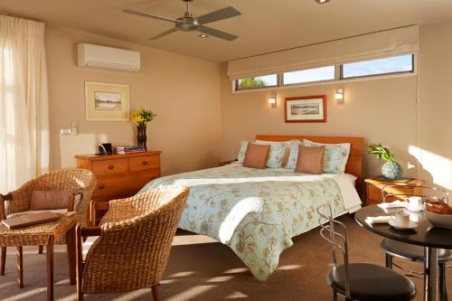 a bedroom with a bed and a table and chairs at Almyra Waterfront Accommodation in Tasman
