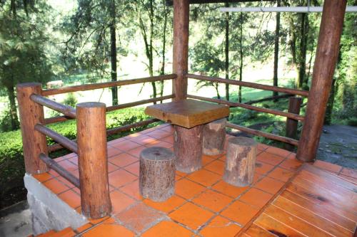 a wooden bench sitting on top of a porch at Cabañas Alpinas López Fontes in Valle de Bravo
