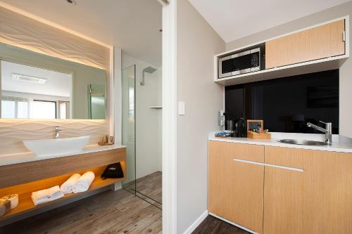 a bathroom with a sink and a mirror at Allure On Ocean Motel in Mollymook