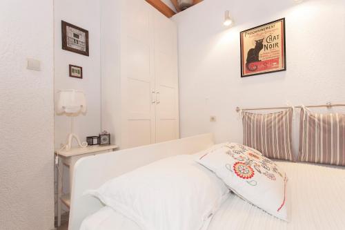 a bedroom with a white bed with a pillow on it at Guesthouse F in Split