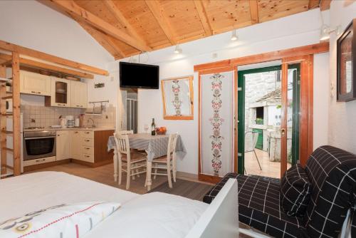 a room with a bed and a kitchen with a table at Guesthouse F in Split