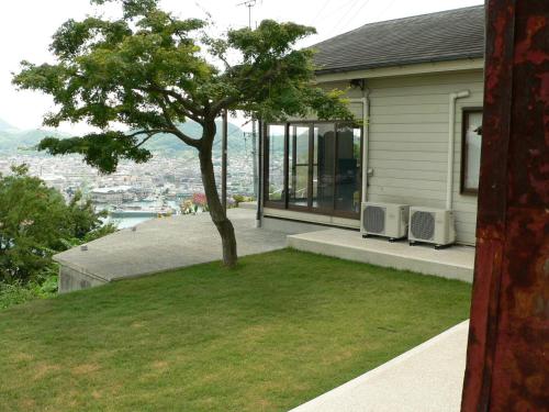 a house with a tree on the side of it at Saka no Kaze in Onomichi