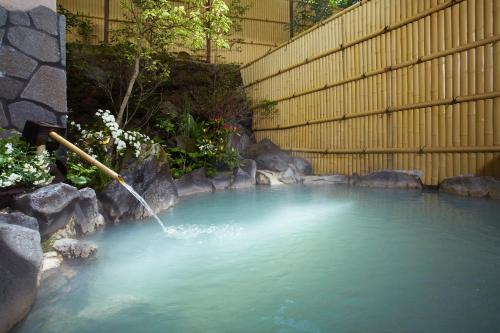 a pool of water with a water hose at Unzen Iwaki Ryokan in Unzen