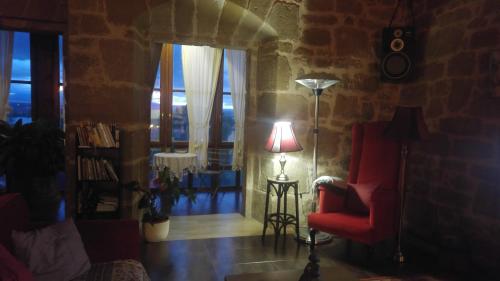 a living room with a red chair and a lamp at Casa Rural Osante in Labastida