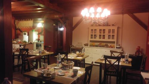 a dining room with tables and chairs and a kitchen at Casa Rural Osante in Labastida