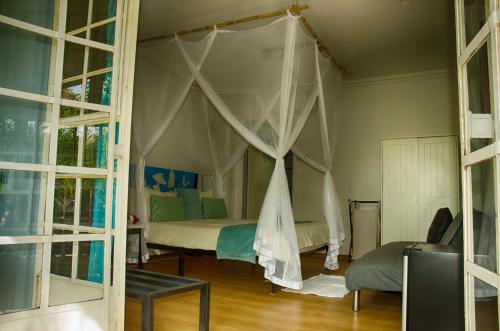 um quarto com uma cama de dossel em The Old House em Kasane