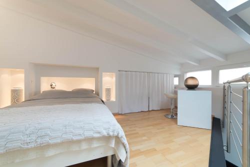 a white bedroom with a bed and a desk at LE LOFT 67 in Strasbourg
