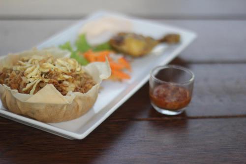a plate with a sandwich and a glass of water at Forriz Hotel Yogyakarta in Yogyakarta