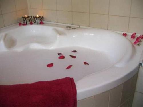 una bañera blanca con pétalos de flores. en Ronit and Mario, en Abirim