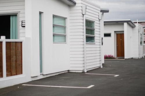 a row of white houses in a parking lot at Broadway Motel & Miro Court Villas in Matamata