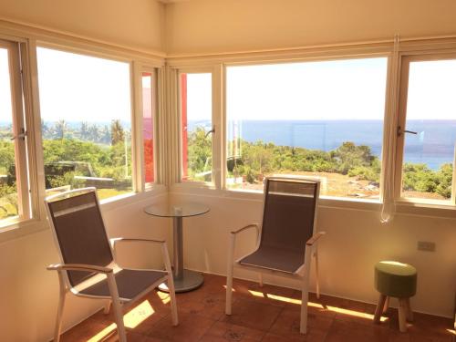 a room with two chairs and a table in front of windows at The Song of Eagle in Donghe