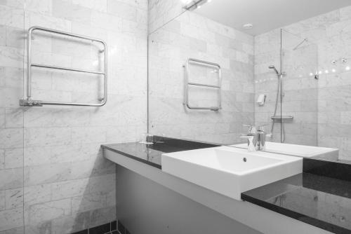 a white bathroom with a sink and a mirror at Quality Hotel Ekoxen in Linköping