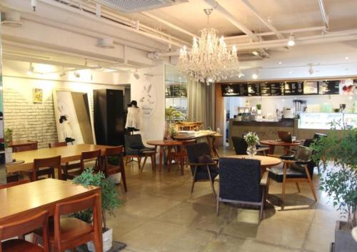 ソウルにあるホテル ザ デザイナーズ ホンデのテーブルと椅子、シャンデリアのあるレストラン