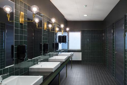 a bathroom with three sinks and a row of mirrors at Quality Hotel Ekoxen in Linköping