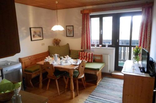 ein Esszimmer mit einem Tisch und einem Sofa in der Unterkunft Leitingerhof in Thalgau
